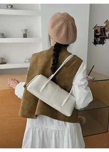 Chic minimalist white shoulder bag displayed in a stylish modern cafe setting