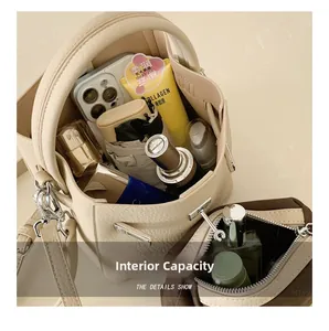 Top view of cream pebbled leather bucket bag showing spacious interior and dark pouch