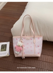 Dettaglio della borsa tote rosa chiaro con stampa cupcake e ciondolo orsetto bianco