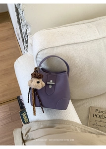 Détail du sac seau lilas avec fermoir rotatif argenté et charm ours en peluche léopard