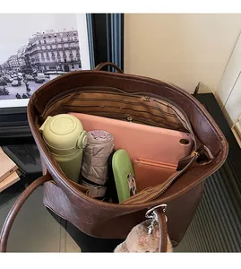 Vista detallada del interior de un bolso tote marrón con gran capacidad para laptop y más