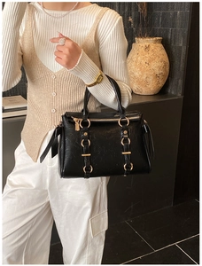 Dettaglio borsa tote in pelle nera con finitura martellata e hardware dorato di lusso