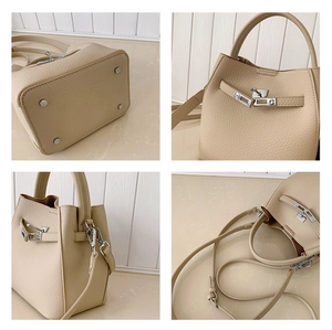 Detail view of beige leather bucket bag showing silver hardware feet and lock system