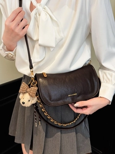 Retro chocolate baguette bag with gold chain and teddy charm on a stylish model