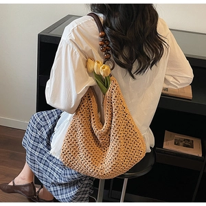 Detail of hollow knit tote bag featuring retro wooden beads and a round handle accent