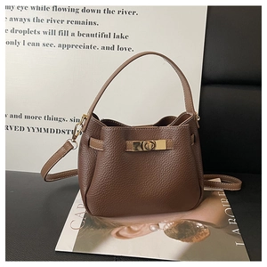 Détail du sac seau en cuir grainé marron foncé avec boucle rectangulaire dorée chic