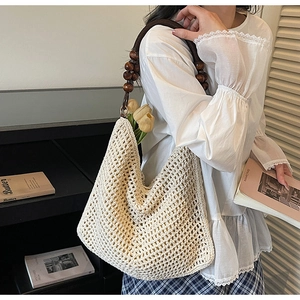 Detail of crochet tote bag with wooden bead handle and vintage hollow knit pattern