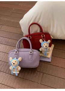 Détail de sacs Boston rouges et violets avec oursons et logo COIH 2DN en relief
