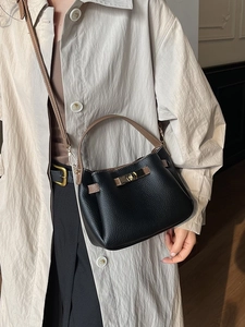 Sac seau en cuir litchi noir avec bretelles marron et fermoir tournant en métal doré