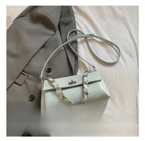 Detail of light blue crossbody bag featuring silver chunky metal chain and turn-lock closure