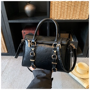Dettaglio della borsa tote nera a pieghe con fibbie dorate e eleganti finiture in metallo