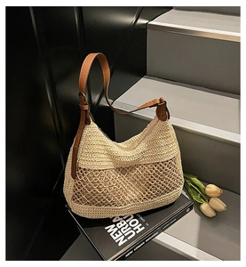 Detail showing beige woven straw bag texture with brown leather strap and zip closure