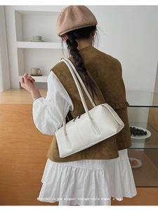 Versatile cream white minimalist baguette shoulder bag shown in a vintage lifestyle setting