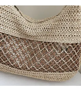 Detail of hollow mesh woven straw shoulder bag featuring contrast color patchwork design