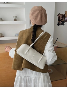 Minimalist white tote bag shown on model in a stylish cafe setting for daily wear