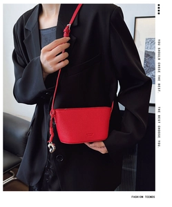 Detail of red lychee grain leather mini bag with silver heart charm and thin strap