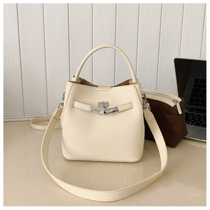 Detail of off-white lychee grain leather bucket bag with silver lock and brown inner pouch