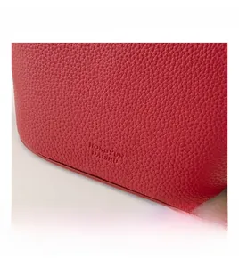Detailed macro view showing red lychee grain leather texture and embossed logo