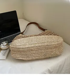 Detailed craftsmanship of a woven bohemian hobo bag with contrast stitching and leather strap