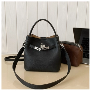 Detail of black lychee grain leather bucket bag with silver twist lock and handle