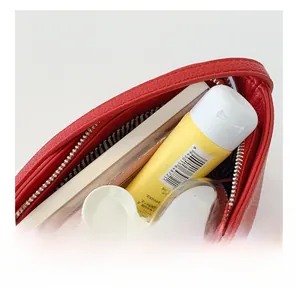 Top-down view of red pebble leather cosmetic bag with striped lining and storage capacity