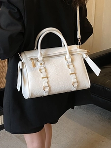 Borsa tote bianca a pieghe con anelli dorati indossata con un blazer nero formale