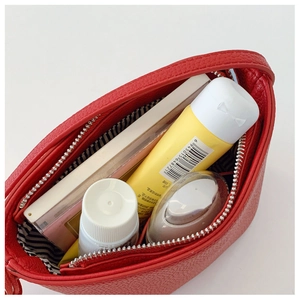 Close-up of red lychee leather cosmetic bag with striped lining and ample storage space