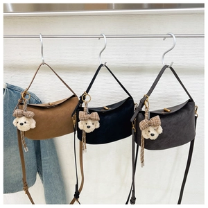 Drei minimalistische Hobo-Taschen in Braun, Schwarz und Grau mit süßen Plüsch-Hundeanhängern