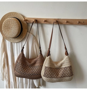 Detail of woven straw hobo bags in coffee and beige with leather shoulder straps