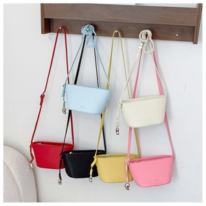 Collection of mini trapezoid crossbody bags in six vibrant colors with metal charms