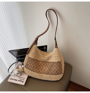 Detail of beige woven straw tote bag with intricate hollow mesh pattern and leather strap