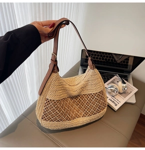 Detailed close-up of straw woven shoulder bag featuring hollow mesh and leather strap