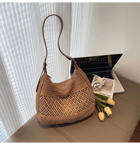 Detail of hand-woven brown straw shoulder bag with zipper and leather strap on bench