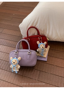 Detailansicht der Boston-Handtaschen in Rot und Violett mit süßen Teddybären-Anhängern