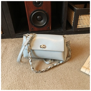 Detail view of the silver chain strap and metal swivel lock on light blue handbag