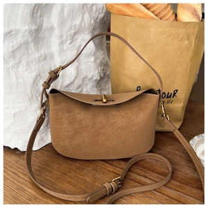 Detailaufnahme der braunen Wildledertasche mit goldenem Verschluss und Lederriemen