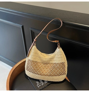 Detail of hand-woven beige straw shoulder bag with hollow mesh and brown leather strap