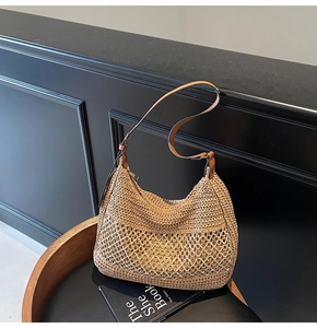 Close-up of woven straw shoulder bag with mesh texture and leather strap details