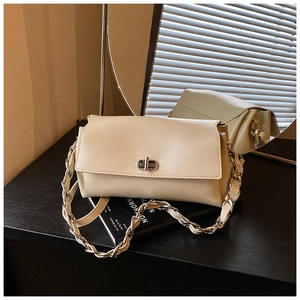 Detailed view of cream white shoulder bag featuring a silver twist lock and chain strap