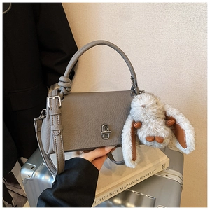 Detail of grey pebble leather handbag with silver twist lock and cute bunny charm