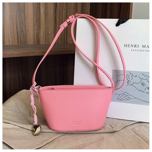 Detail of pink half-moon crossbody bag in pebble leather with heart metal pendant zipper