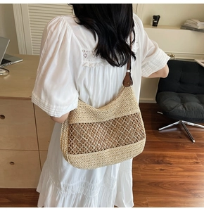 Detail of a woven straw shoulder bag with contrast leather strap and cutout design