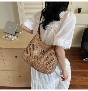 Detail of woven straw tote bag with fine hollow texture and premium leather strap