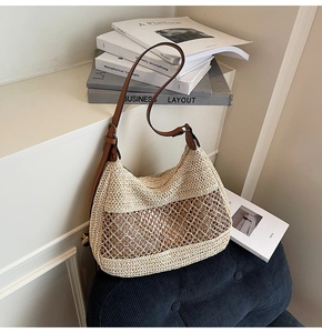 Close-up of woven straw tote bag featuring brown leather strap and contrast knit detail