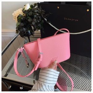 Detail of pink lychee leather bucket bag with silver metal buckle and adjustable strap