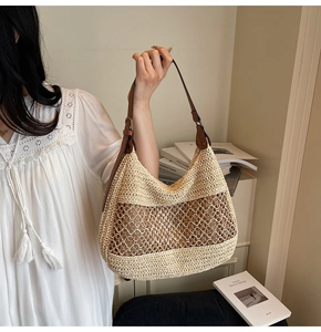 Detail showing the mixed beige and brown woven texture and leather strap of the shoulder bag