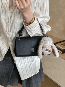 Classic black pebbled leather handbag with silver lock and a cute white rabbit pendant