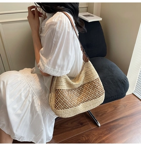 Detail of hand-woven hobo bag with grid hollow pattern and brown leather strap