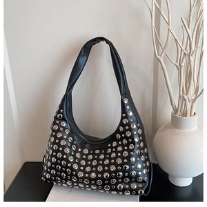Detail der schwarzen Hobo-Tasche mit silbernen Metallnieten und Reißverschluss