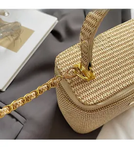 Detailansicht der Strohtasche mit hellgoldener Kette und Metallverschluss in Nahaufnahme